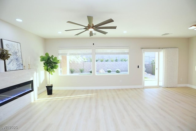 2623 Red Planet St, Henderson, NV 89044 - unfurnished living room with wood finished floors, ceiling fan, a glass covered fireplace, baseboards, and recessed lighting