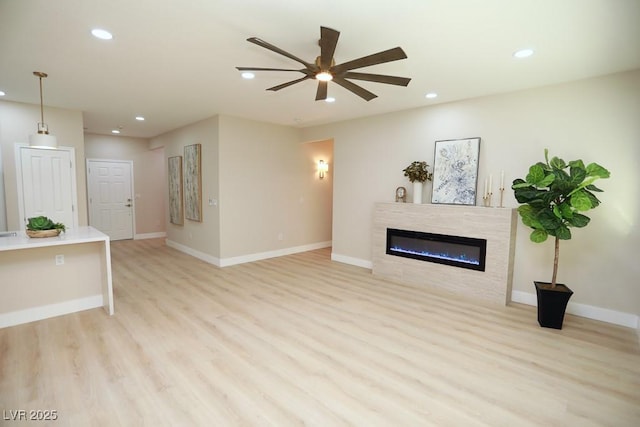 2623 Red Planet St, Henderson, NV 89044 - living area with light wood-style flooring, recessed lighting, ceiling fan, a glass covered fireplace, and baseboards