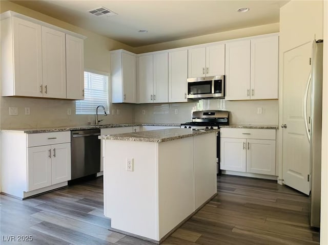 8793 Candelabra Ct, Las Vegas, NV 89148 - kitchen featuring stainless steel appliances, dark wood-style floors, white cabinetry, recessed lighting, and a kitchen island