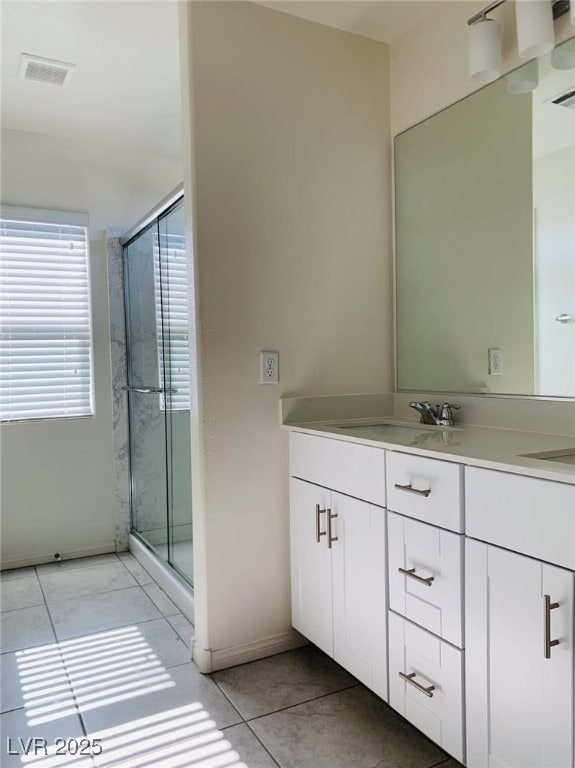 8793 Candelabra Ct, Las Vegas, NV 89148 - full bath with double vanity, a shower stall, tile patterned flooring, and baseboards