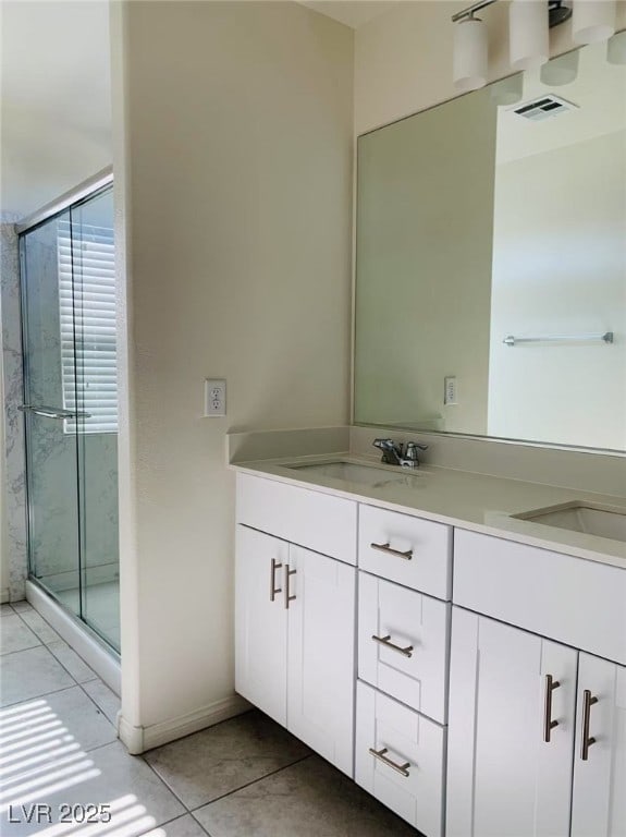 8793 Candelabra Ct, Las Vegas, NV 89148 - bathroom featuring double vanity, tile patterned flooring, a stall shower, and baseboards