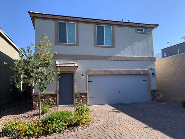 8793 Candelabra Ct, Las Vegas, NV 89148 - view of front of house with stucco siding, a garage, driveway, and stone siding