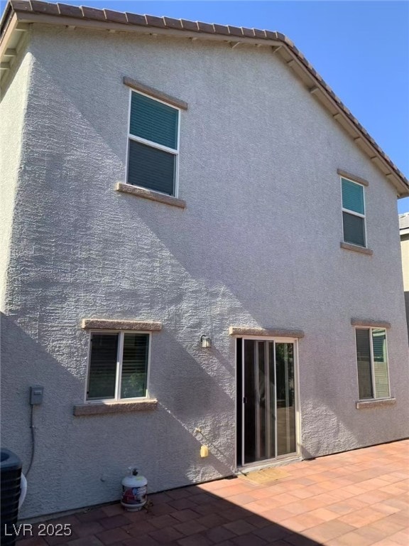 8793 Candelabra Ct, Las Vegas, NV 89148 - rear view of house featuring stucco siding, a patio area, and central AC unit