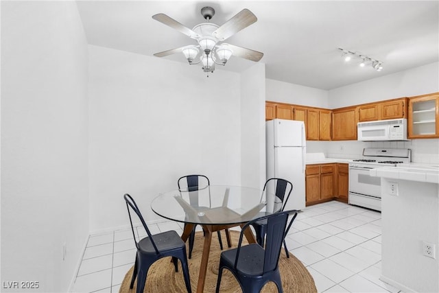 1830 N Buffalo Dr Unit 2014, Las Vegas, NV 89128 - kitchen featuring white appliances, light tile patterned flooring, tile countertops, brown cabinetry, and ceiling fan