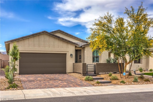 2114 Thelen Ave, North Las Vegas, NV 89086 - ranch-style house with a garage, decorative driveway, a gate, board and batten siding, and stucco siding
