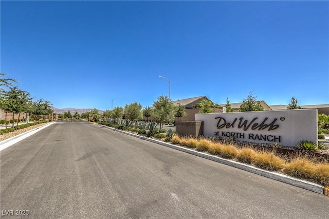2114 Thelen Ave, North Las Vegas, NV 89086 - view of asphalt road with street lighting, curbs, and a gated entry