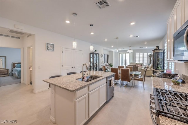 2114 Thelen Ave, North Las Vegas, NV 89086 - kitchen featuring appliances with stainless steel finishes, a sink, open floor plan, white cabinetry, and recessed lighting