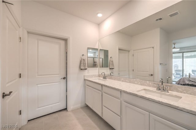 2114 Thelen Ave, North Las Vegas, NV 89086 - bathroom featuring double vanity, tile patterned floors, connected bathroom, and baseboards