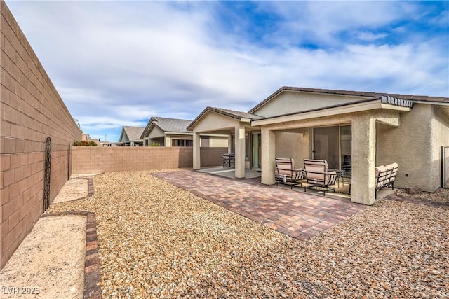 2114 Thelen Ave, North Las Vegas, NV 89086 - rear view of property with stucco siding, a fenced backyard, and a patio