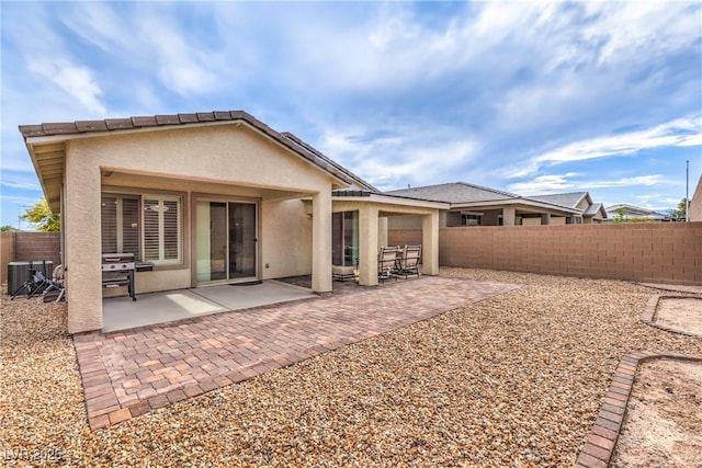 2114 Thelen Ave, North Las Vegas, NV 89086 - back of property with stucco siding, a fenced backyard, central air condition unit, and a patio