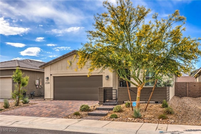 2114 Thelen Ave, North Las Vegas, NV 89086 - view of front facade featuring a garage, decorative driveway, and stucco siding