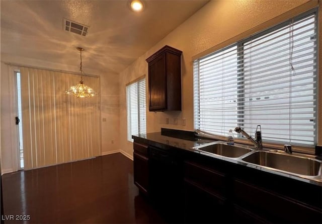 8218 Golden Flowers St, Las Vegas, NV 89139 - kitchen featuring a sink, dark countertops, baseboards, a chandelier, and pendant lighting