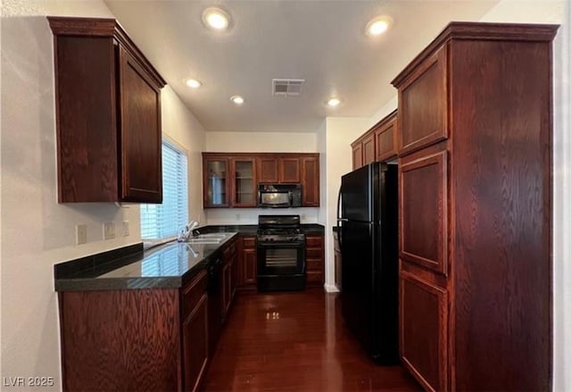 8218 Golden Flowers St, Las Vegas, NV 89139 - kitchen with black appliances, a sink, dark countertops, dark wood-style flooring, and glass insert cabinets