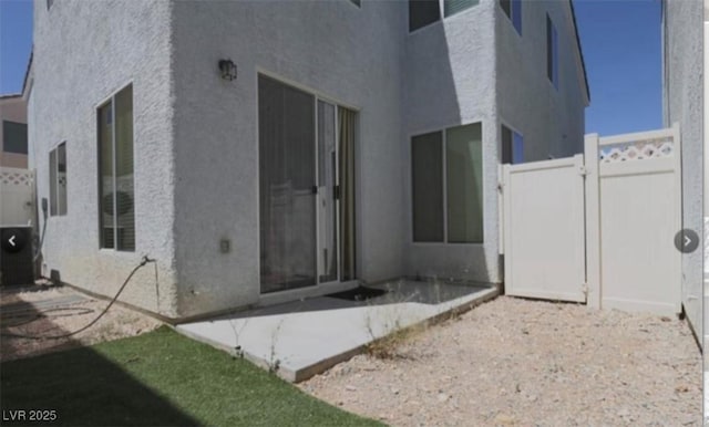 8218 Golden Flowers St, Las Vegas, NV 89139 - back of house with stucco siding, a patio, and a gate