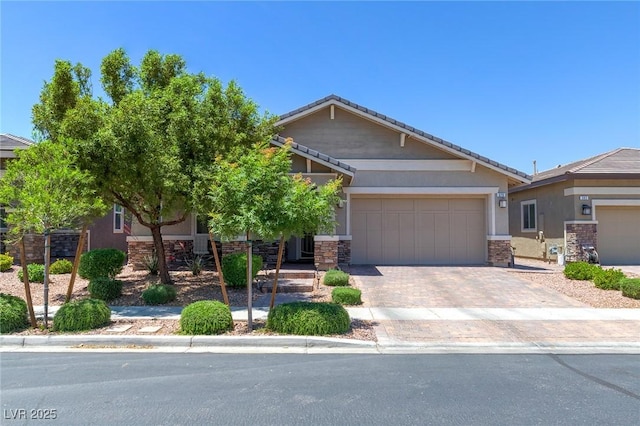 379 Mano Destra Ln, Henderson, NV 89011 - view of front of home with stone siding, stucco siding, a tile roof, decorative driveway, and a garage