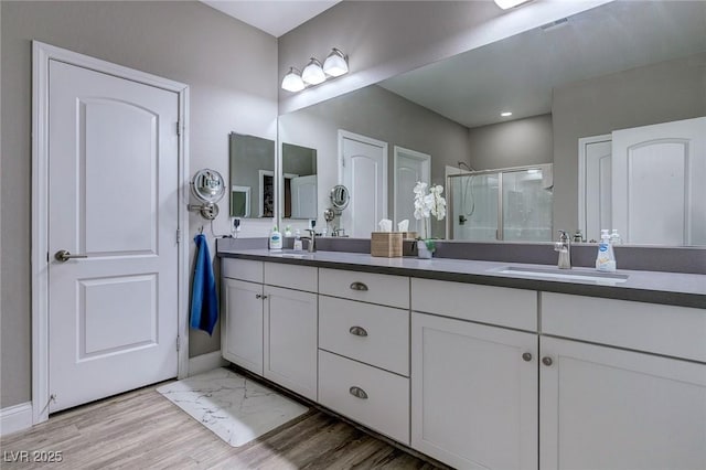 379 Mano Destra Ln, Henderson, NV 89011 - full bath featuring a stall shower, double vanity, baseboards, wood finished floors, and recessed lighting