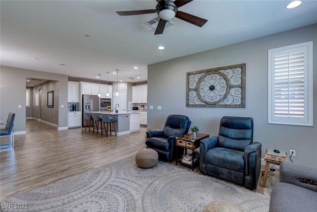 379 Mano Destra Ln, Henderson, NV 89011 - living area featuring a ceiling fan, light wood-type flooring, recessed lighting, baseboards, and healthy amount of natural light