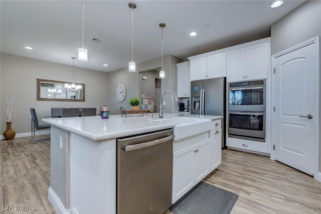 379 Mano Destra Ln, Henderson, NV 89011 - kitchen featuring appliances with stainless steel finishes, a sink, light wood finished floors, white cabinets, and recessed lighting