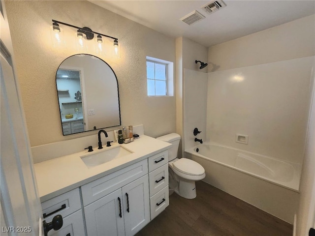 8720 Prairie Hill Dr, Las Vegas, NV 89134 - bathroom with toilet, wood finished floors, vanity, bathtub / shower combination, and a textured wall