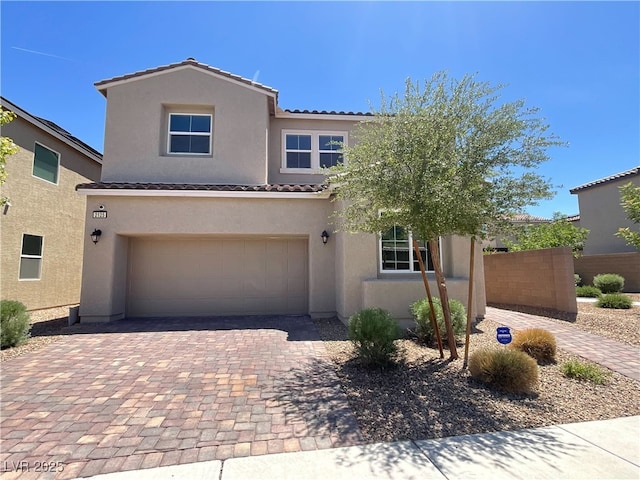 2125 Stone Well Rd, North Las Vegas, NV 89031 - view of front of home featuring a tiled roof, stucco siding, decorative driveway, and an attached garage