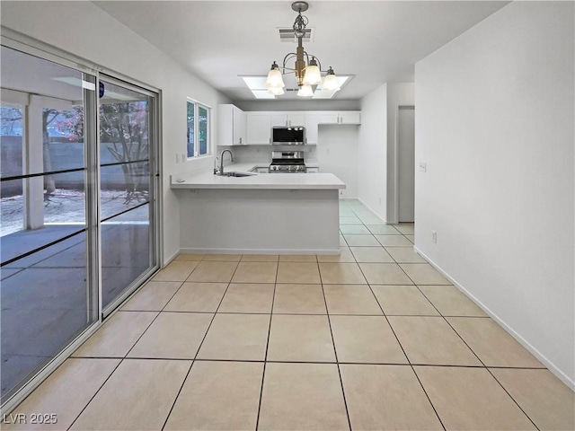 2125 Stone Well Rd, North Las Vegas, NV 89031 - kitchen featuring a sink, appliances with stainless steel finishes, light countertops, a peninsula, and white cabinetry