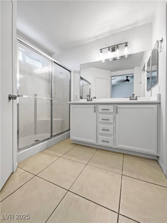 2125 Stone Well Rd, North Las Vegas, NV 89031 - full bathroom with tile patterned floors, double vanity, a ceiling fan, and an enclosed shower