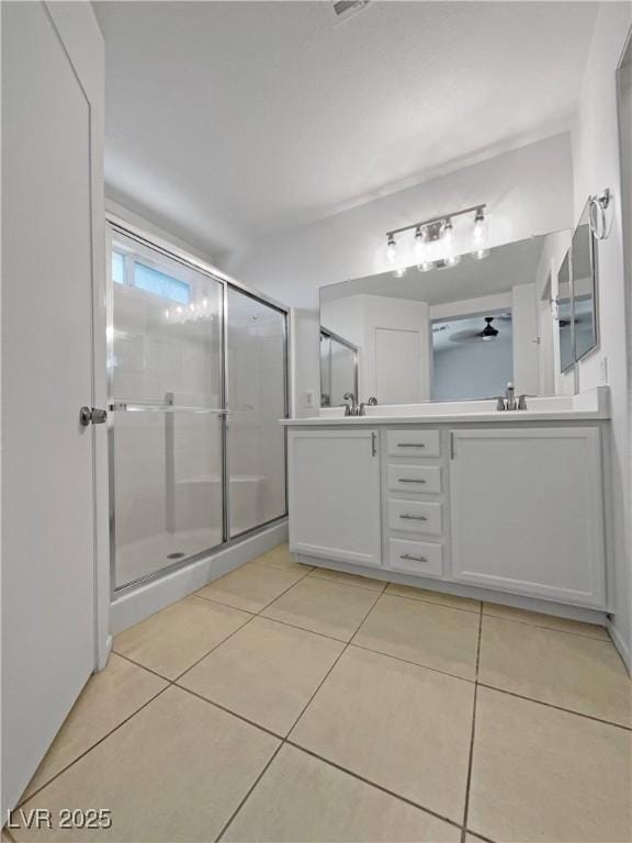 2125 Stone Well Rd, North Las Vegas, NV 89031 - full bathroom with double vanity, tile patterned flooring, an enclosed shower, and a ceiling fan