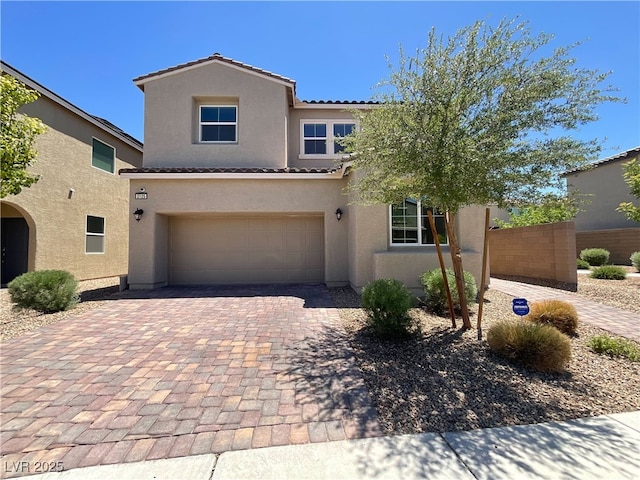 2125 Stone Well Rd, North Las Vegas, NV 89031 - view of front of house featuring stucco siding, a tiled roof, an attached garage, and decorative driveway