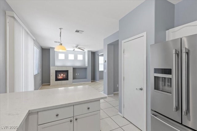 180 Duck Hollow Ave, Las Vegas, NV 89148 - kitchen featuring high quality fridge, a ceiling fan, white cabinets, a tile fireplace, and light tile patterned floors