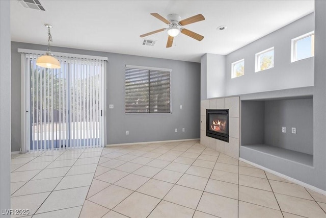 180 Duck Hollow Ave, Las Vegas, NV 89148 - unfurnished living room featuring a tiled fireplace, a ceiling fan, light tile patterned floors, and baseboards