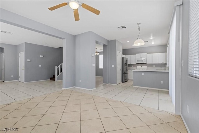 180 Duck Hollow Ave, Las Vegas, NV 89148 - unfurnished living room with a ceiling fan, light tile patterned floors, stairs, and baseboards