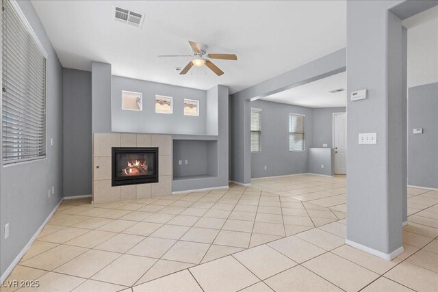 180 Duck Hollow Ave, Las Vegas, NV 89148 - unfurnished living room with a ceiling fan, light tile patterned floors, built in features, a tiled fireplace, and baseboards