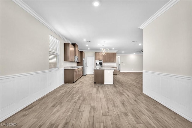 4510 Rubious Ave, North Las Vegas, NV 89084 - kitchen with open floor plan, ornamental molding, appliances with stainless steel finishes, light countertops, and an island with sink