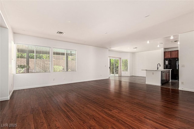 9173 Weeping Hollow Ave, Las Vegas, NV 89178 - unfurnished living room featuring dark wood-style flooring, a sink, baseboards, and recessed lighting