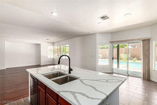 9173 Weeping Hollow Ave, Las Vegas, NV 89178 - kitchen with a sink, open floor plan, baseboards, stainless steel dishwasher, and wood finished floors