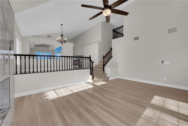 1611 Buffalo Trail Dr, Henderson, NV 89014 - unfurnished living room featuring ceiling fan, high vaulted ceiling, a chandelier, light wood-type flooring, and stairway