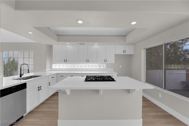 1611 Buffalo Trail Dr, Henderson, NV 89014 - kitchen with dishwasher, a sink, a raised ceiling, gas stovetop, and light wood-type flooring