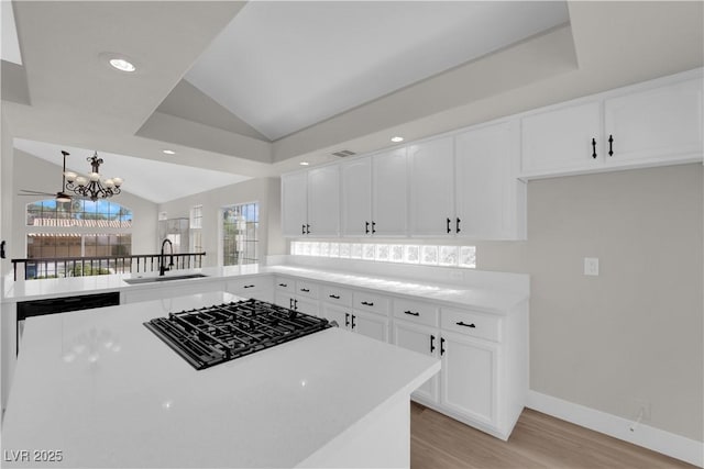 1611 Buffalo Trail Dr, Henderson, NV 89014 - kitchen with a sink, cooktop, light wood-style flooring, vaulted ceiling, and a chandelier