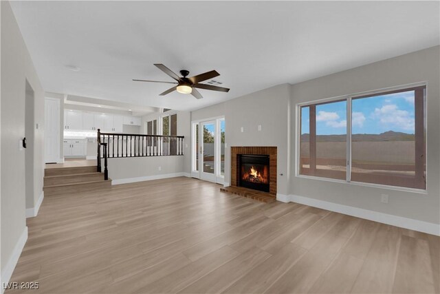 1611 Buffalo Trail Dr, Henderson, NV 89014 - unfurnished living room featuring ceiling fan, baseboards, light wood finished floors, and a brick fireplace