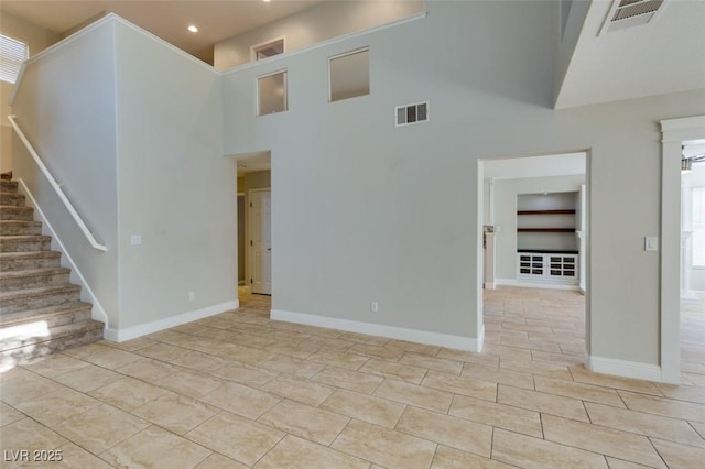 1917 Badger Canyon Ave, North Las Vegas, NV 89031 - unfurnished living room featuring stairs, a high ceiling, recessed lighting, baseboards, and light tile patterned flooring