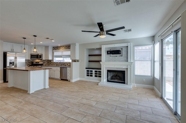 1917 Badger Canyon Ave, North Las Vegas, NV 89031 - kitchen featuring appliances with stainless steel finishes, open floor plan, decorative backsplash, white cabinetry, and recessed lighting