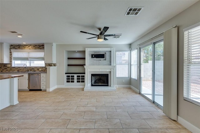 1917 Badger Canyon Ave, North Las Vegas, NV 89031 - unfurnished living room featuring ceiling fan, a sink, a brick fireplace, and baseboards