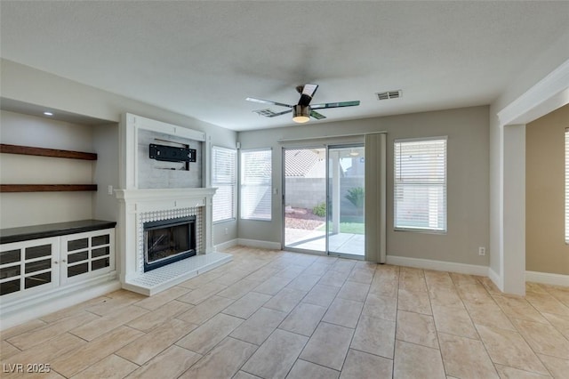 1917 Badger Canyon Ave, North Las Vegas, NV 89031 - unfurnished living room featuring ceiling fan, a fireplace with raised hearth, and baseboards