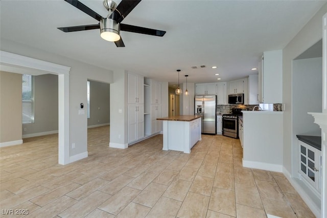 1917 Badger Canyon Ave, North Las Vegas, NV 89031 - kitchen with appliances with stainless steel finishes, a ceiling fan, decorative backsplash, open floor plan, and recessed lighting