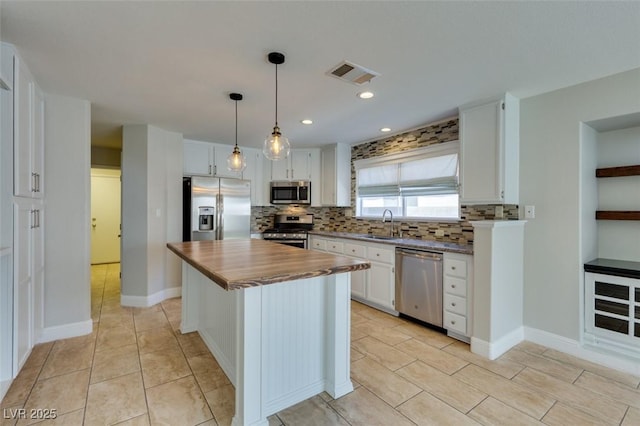 1917 Badger Canyon Ave, North Las Vegas, NV 89031 - kitchen featuring stainless steel appliances, butcher block countertops, backsplash, white cabinetry, and pendant lighting