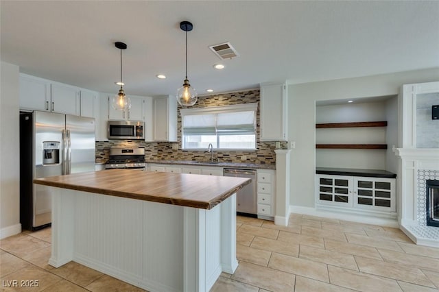 1917 Badger Canyon Ave, North Las Vegas, NV 89031 - kitchen with stainless steel appliances, butcher block counters, decorative backsplash, light tile patterned flooring, and a center island