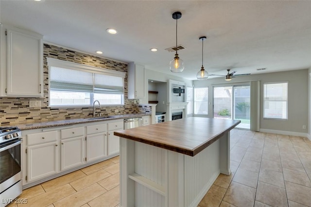 1917 Badger Canyon Ave, North Las Vegas, NV 89031 - kitchen featuring a fireplace, appliances with stainless steel finishes, tasteful backsplash, a sink, and a ceiling fan