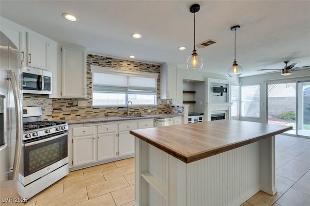 1917 Badger Canyon Ave, North Las Vegas, NV 89031 - kitchen with stainless steel appliances, a fireplace, a sink, butcher block countertops, and light tile patterned floors