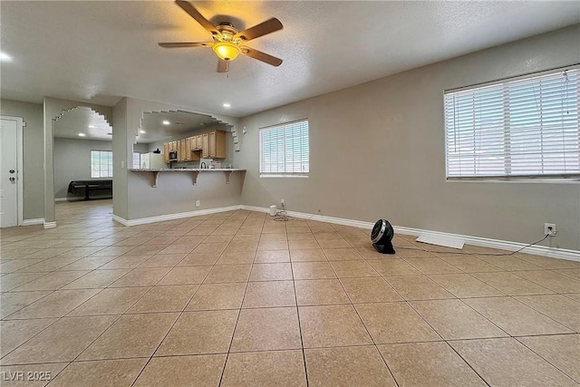 6929 Montcliff Ave, Las Vegas, NV 89147 - unfurnished living room with a ceiling fan, plenty of natural light, light tile patterned flooring, recessed lighting, and a textured ceiling