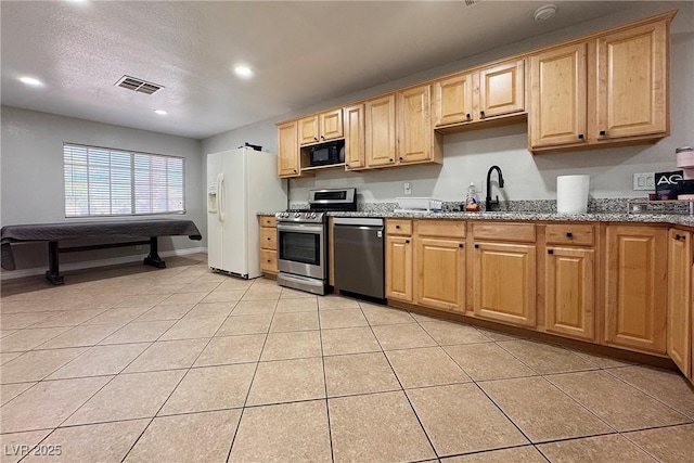 6929 Montcliff Ave, Las Vegas, NV 89147 - kitchen featuring stainless steel appliances, a sink, light tile patterned floors, stone countertops, and light brown cabinets